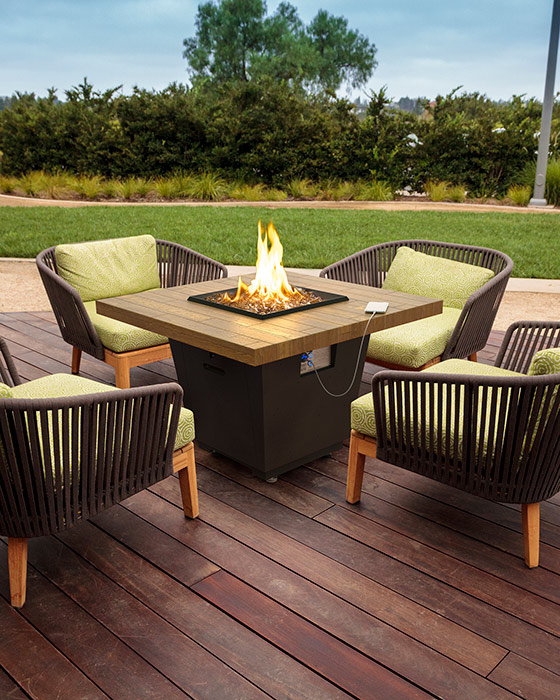 American Fyre Designs Cosmo Chat Height Fire Table on a deck in someones backyard