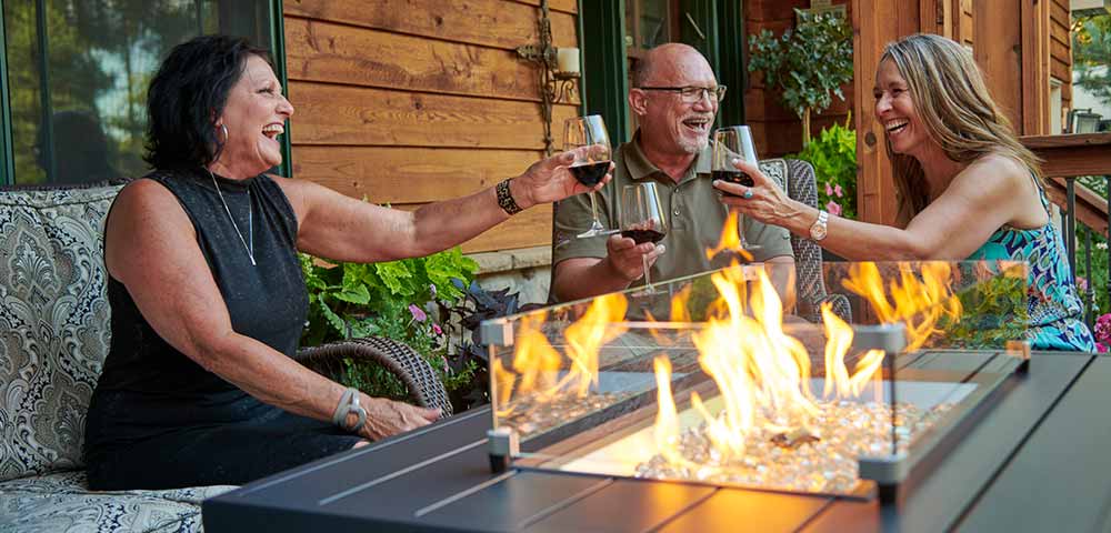 Friends enjoying wine at a fire pit table