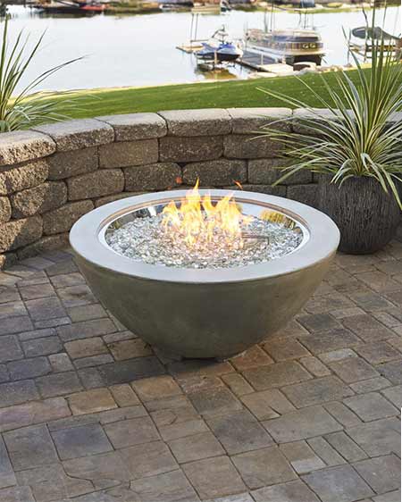 Cove Gas Fire Pit by The Outdoor GreatRoom Company in a lifestyle heading on a patio