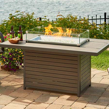 Brooks Rectangular Fire Table by The Outdoor GreatRoom company near a lake